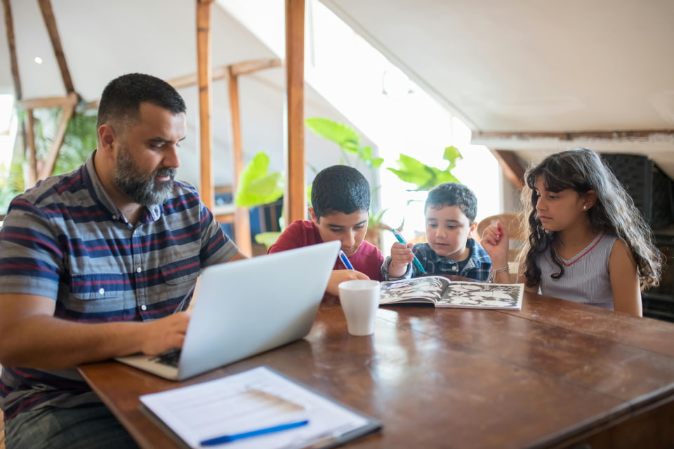 man talking to counselor with kids at round table