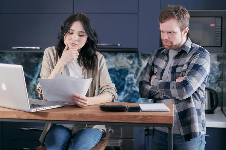 man woman looking at divorce papers discussing next steps on laptop