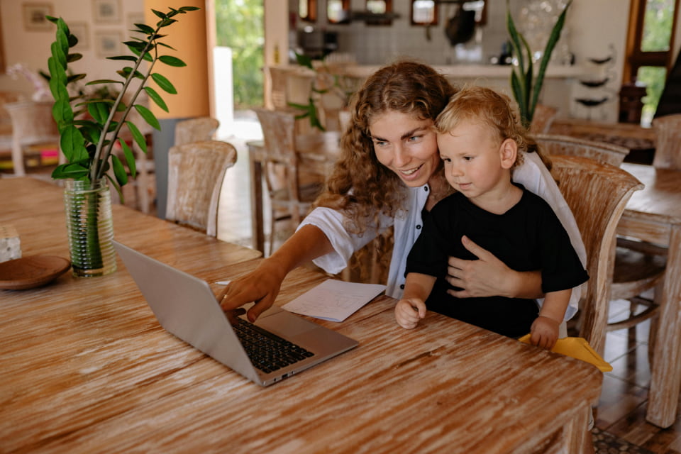 woman with child pointing to laptop
